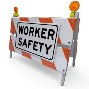An orange and white blockade with the words Worker Safety to represent danger, warning and caution in the workplace and occupational hazards and conditions