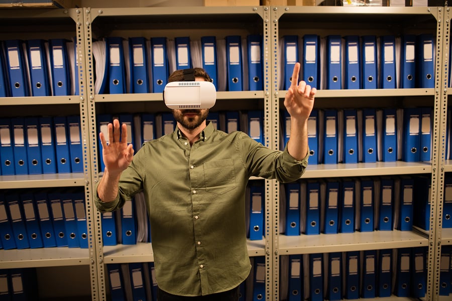 Virtual Teams - Businessman experiencing virtual reality in file storage room at workplace